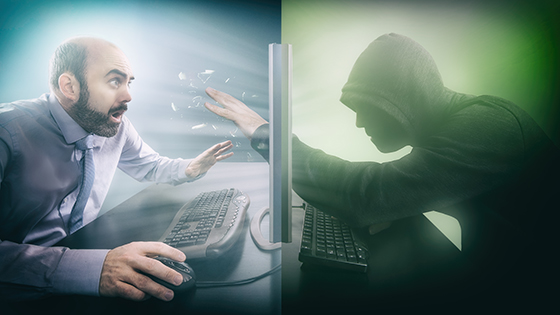 Concept of a hacker reaching through a screen towards a businessman.
