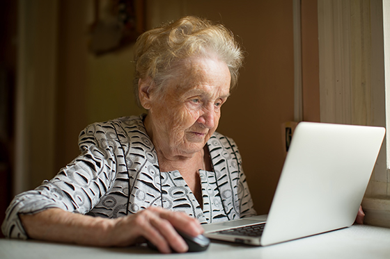 Old woman working on a laptop.