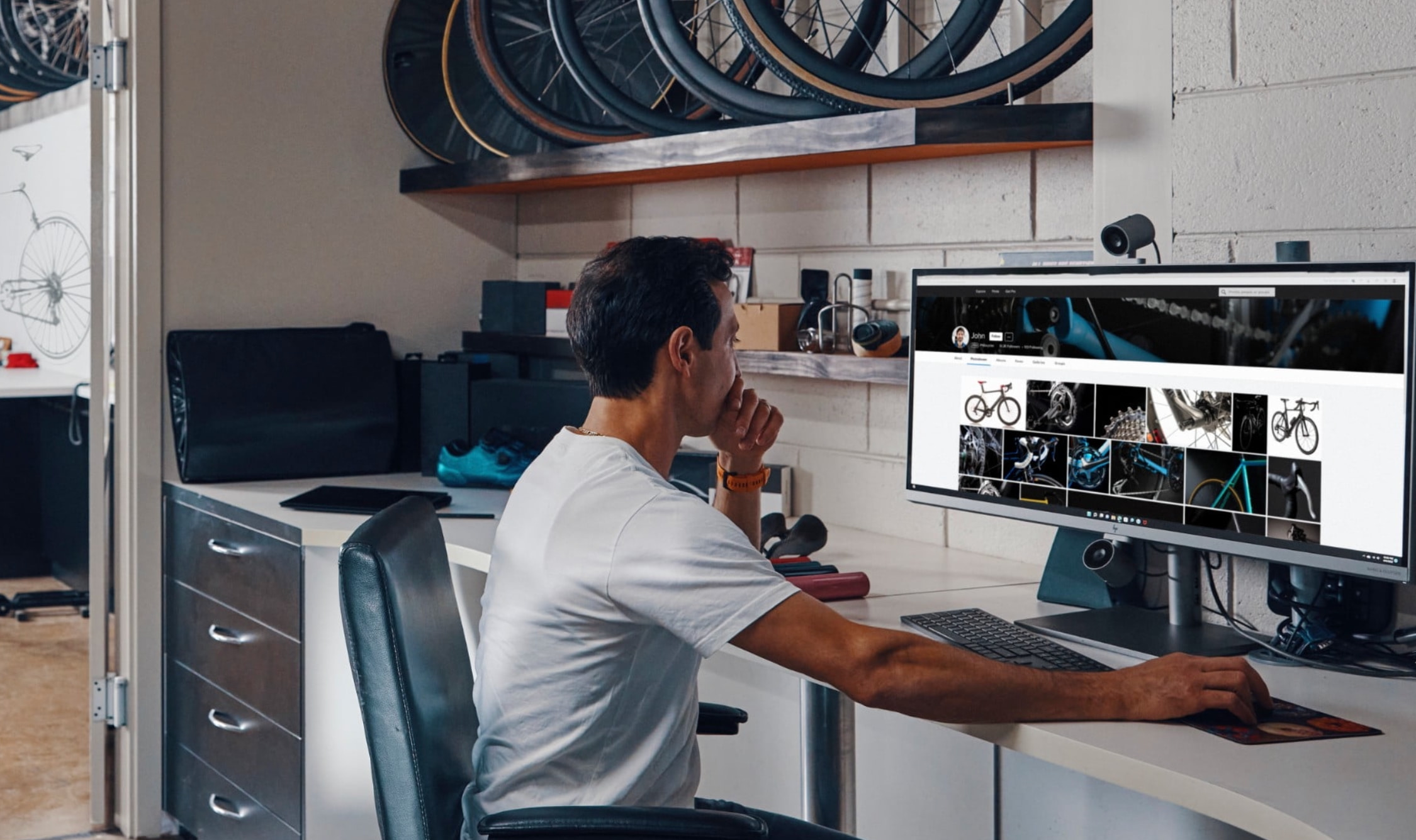 Man working on a computer looking at bike parts.